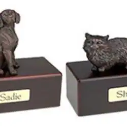 Two small animal figurines, one of a dog and one of a cat, each mounted on a dark rectangular base with nameplates labeled "Sadie" and "Shadow," commemorate beloved pets in TX, often chosen for pet cremation Harris County services.