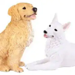 Two dog figurines, one golden and sitting with its tongue out, and one white and lying down, both facing forward against a white background—a touching tribute for those considering pet cremation in Harris County, TX.
